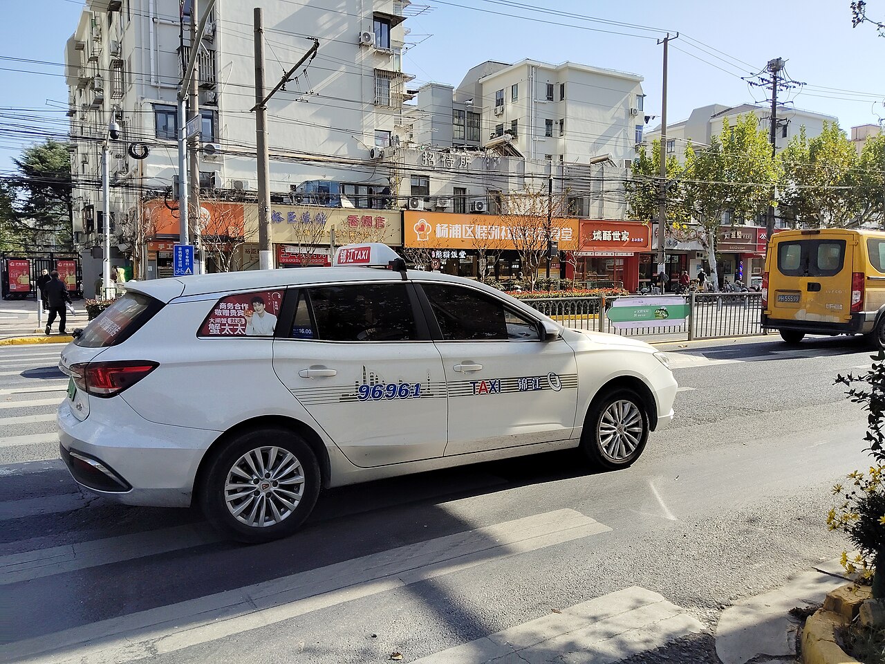Taxi trắng rẽ qua ngã tư ở Thượng Hải, minh hoạ các từ 路口, 右转, 停车 khi đi taxi